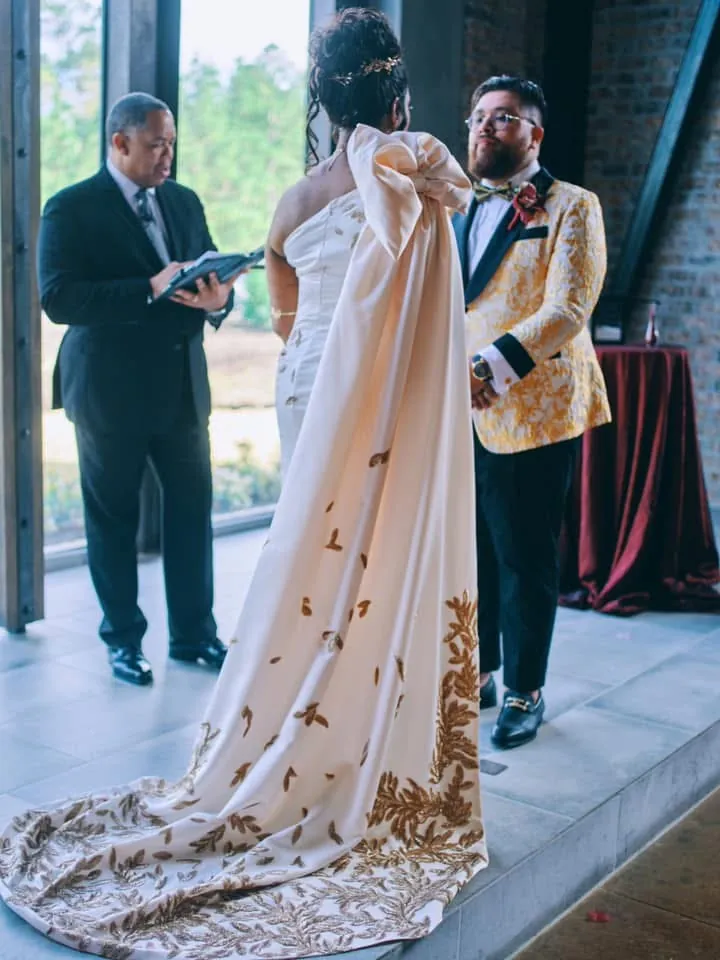 Bride in an ivory gown with a long train of hand-applied gold leaves